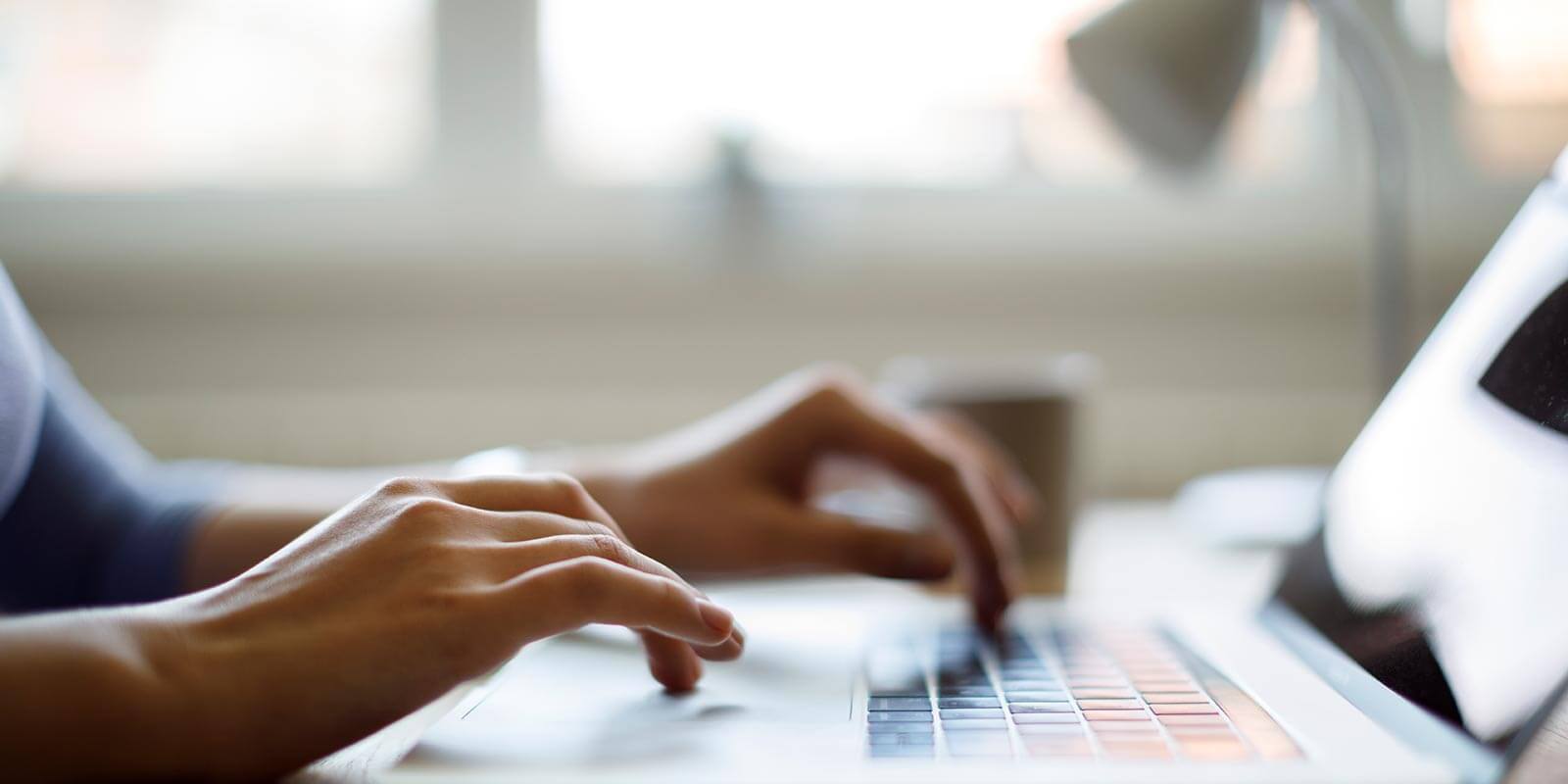 student typing on laptop